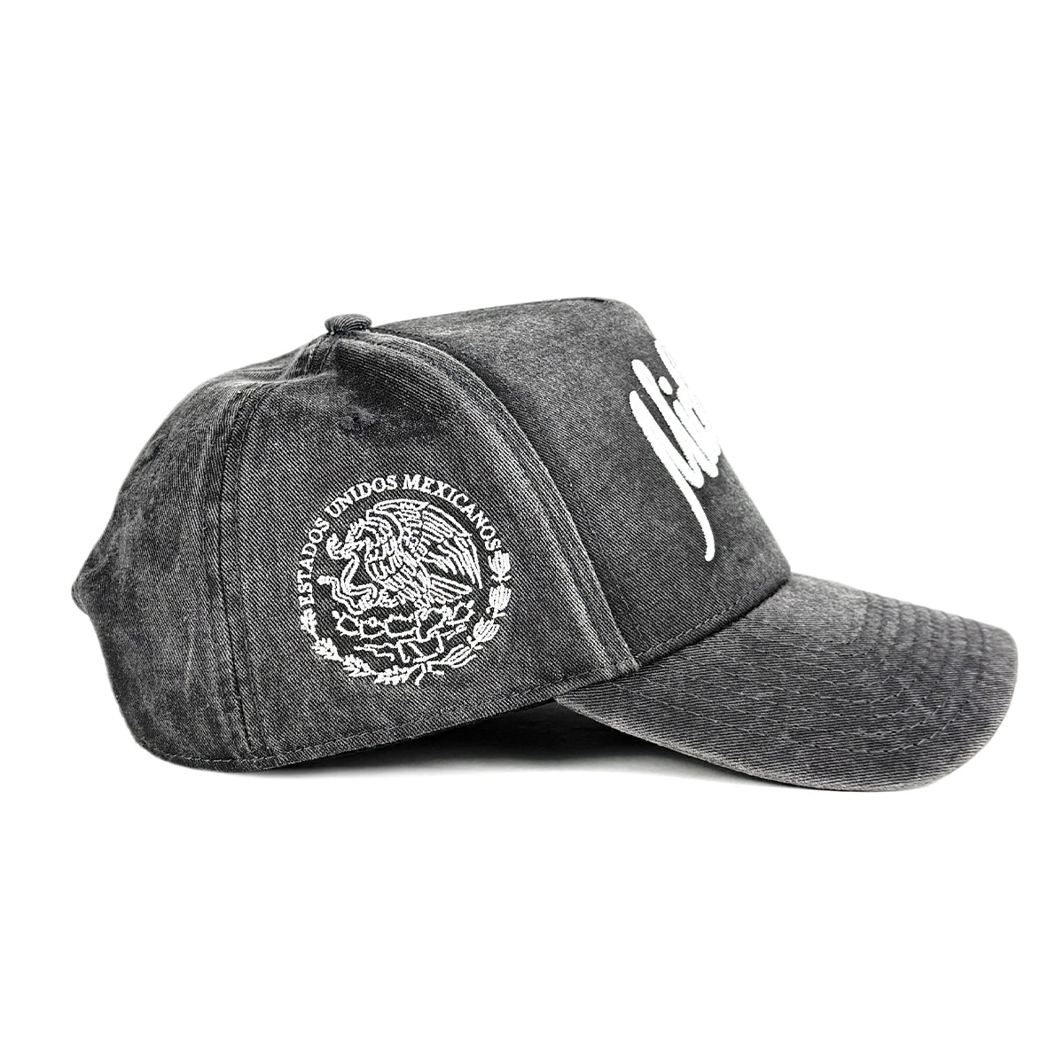 A dark gray acid-wash baseball cap featuring a white embroidered Mexican coat of arms on the side and a white script logo on the front, set against a plain white background.