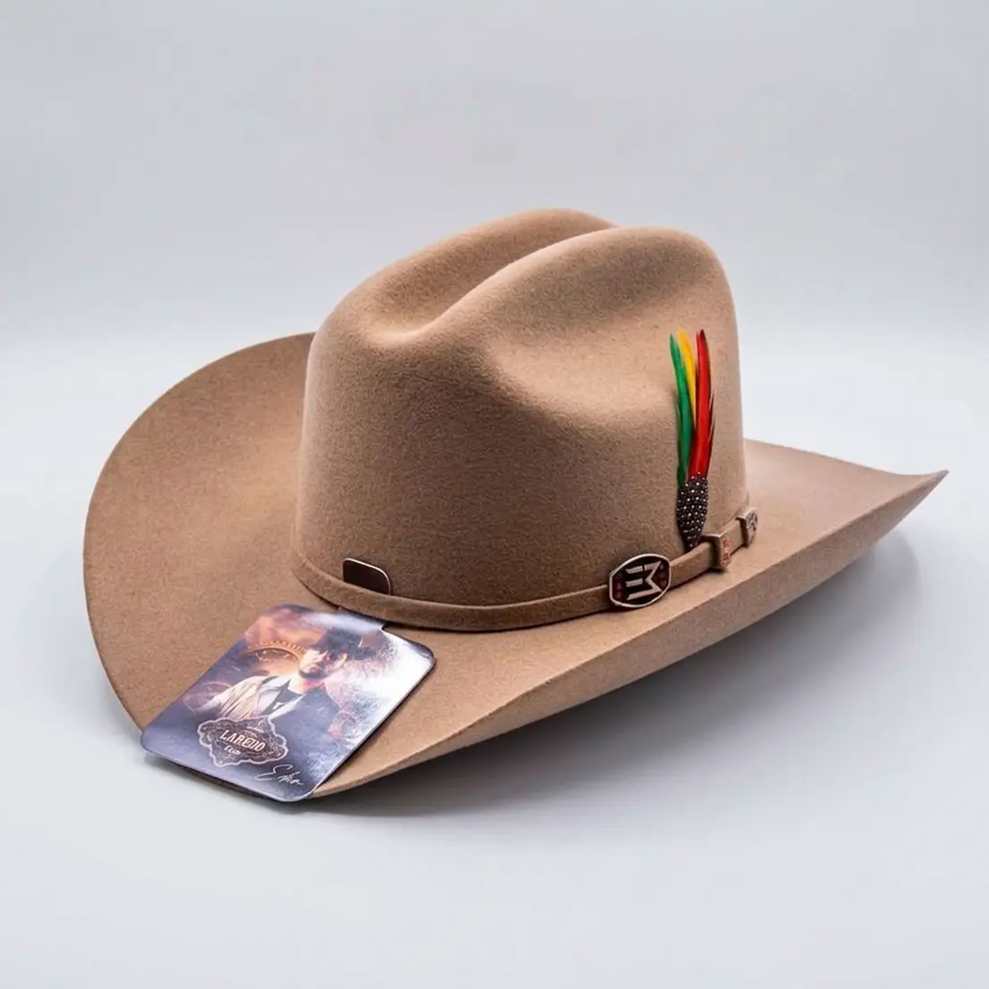 Three-quarter studio shot of the official Laredo Hats Eden Muñoz camel wool felt tejana showing the cattleman crown, colorful feather accent, and authentic hang tag.