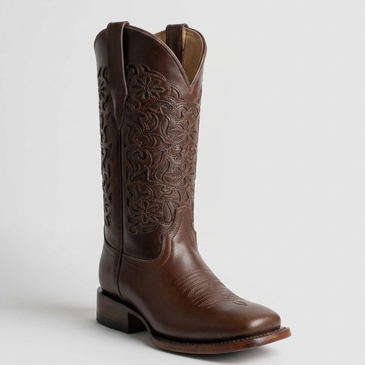 Lirac women's brown square toe cowgirl boot with intricate embossing on a light gray background.