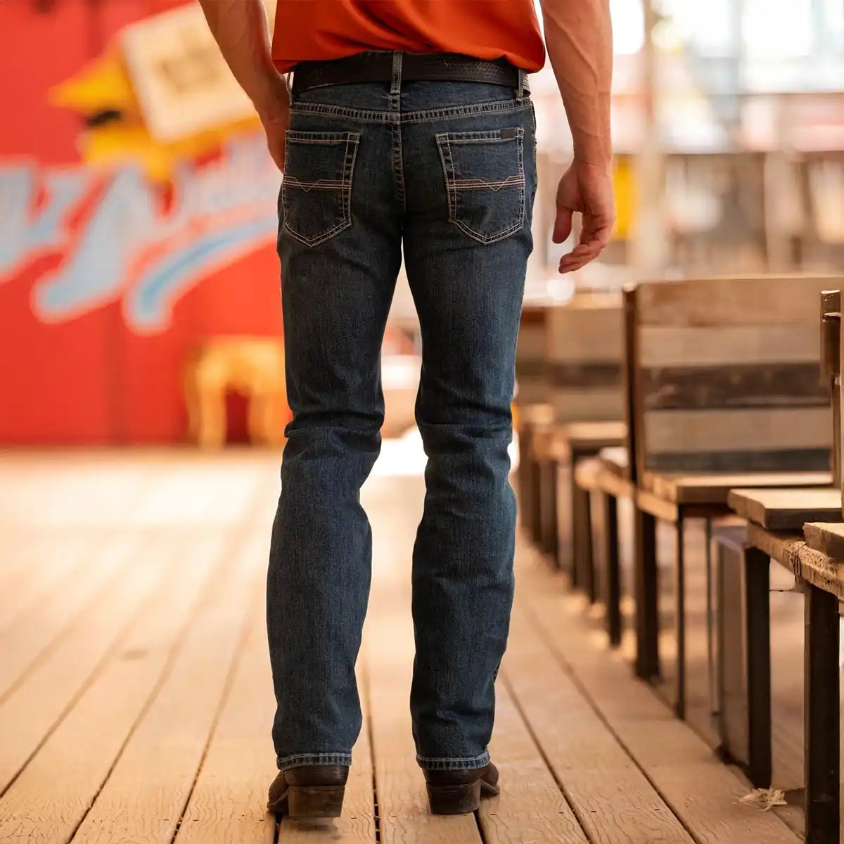 Back view of a man wearing Rock & Roll Denim Vintage '46 Revolver medium wash slim straight jeans with ivory stitched back pockets.