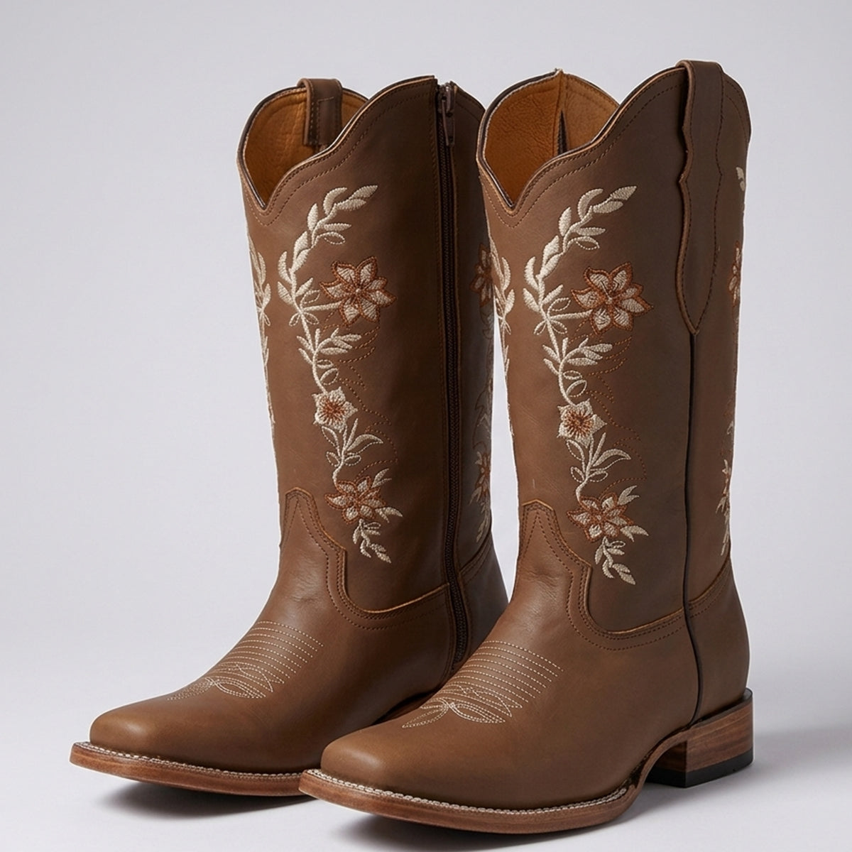 La Sierra tang brown leather square toe cowgirl boots with white floral embroidery on the shafts, shown against a neutral gray background.