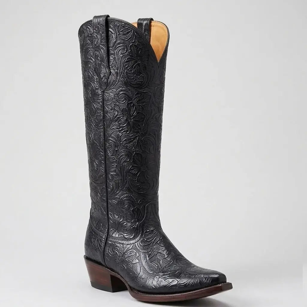 Three-quarter studio profile of the Lirac Women's 17-inch tall black floral tooled leather boot showing the snip toe, 2-inch heel, and detailed floral embossing.
