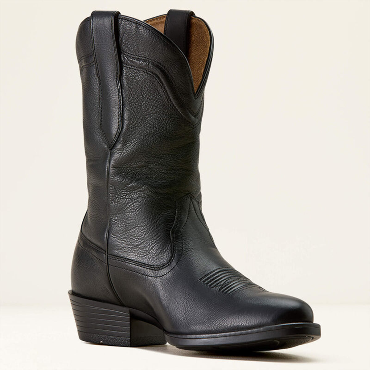 Ariat men's black leather cowboy boot on a beige background.