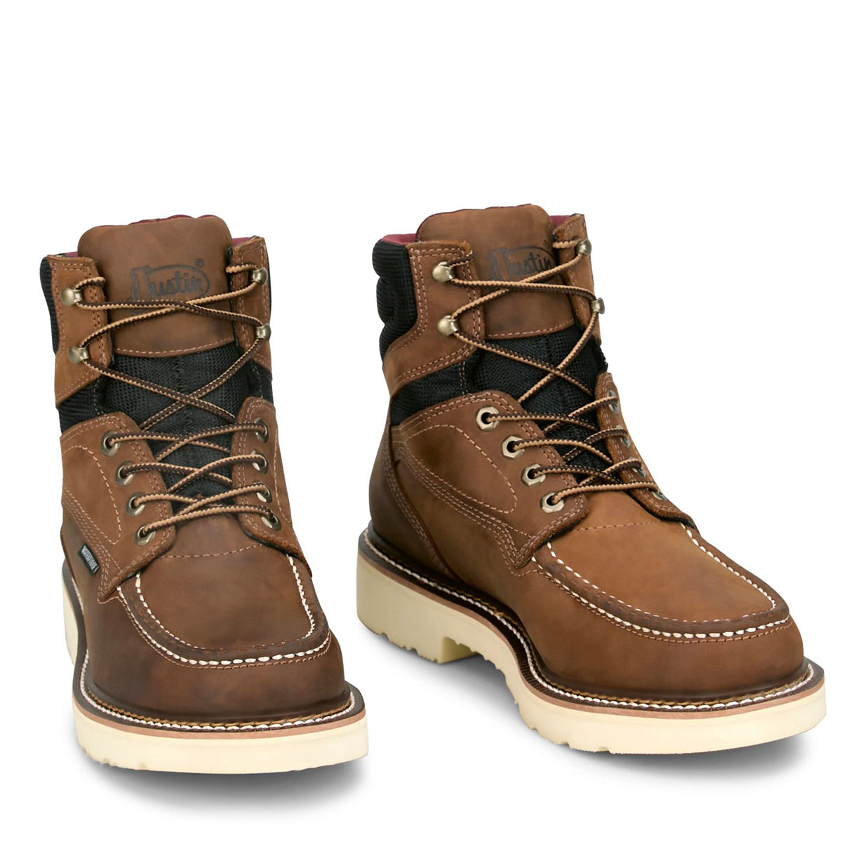 Pair of Justin brown leather mocc tor work boots with white soles on a white background.