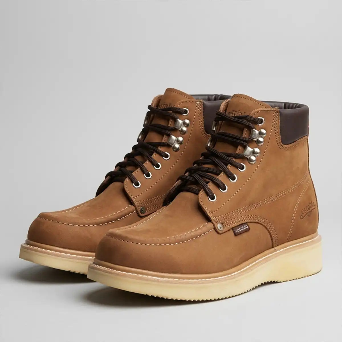 Pair of Establo Men's 6-inch soft toe moc toe work boots in tan nubuck leather displayed on a grey background.