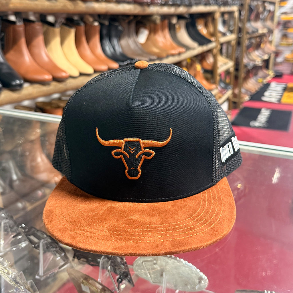 Front close-up retail view of the Rodeo Bully trucker hat sitting on a glass counter inside a Western storefront.
