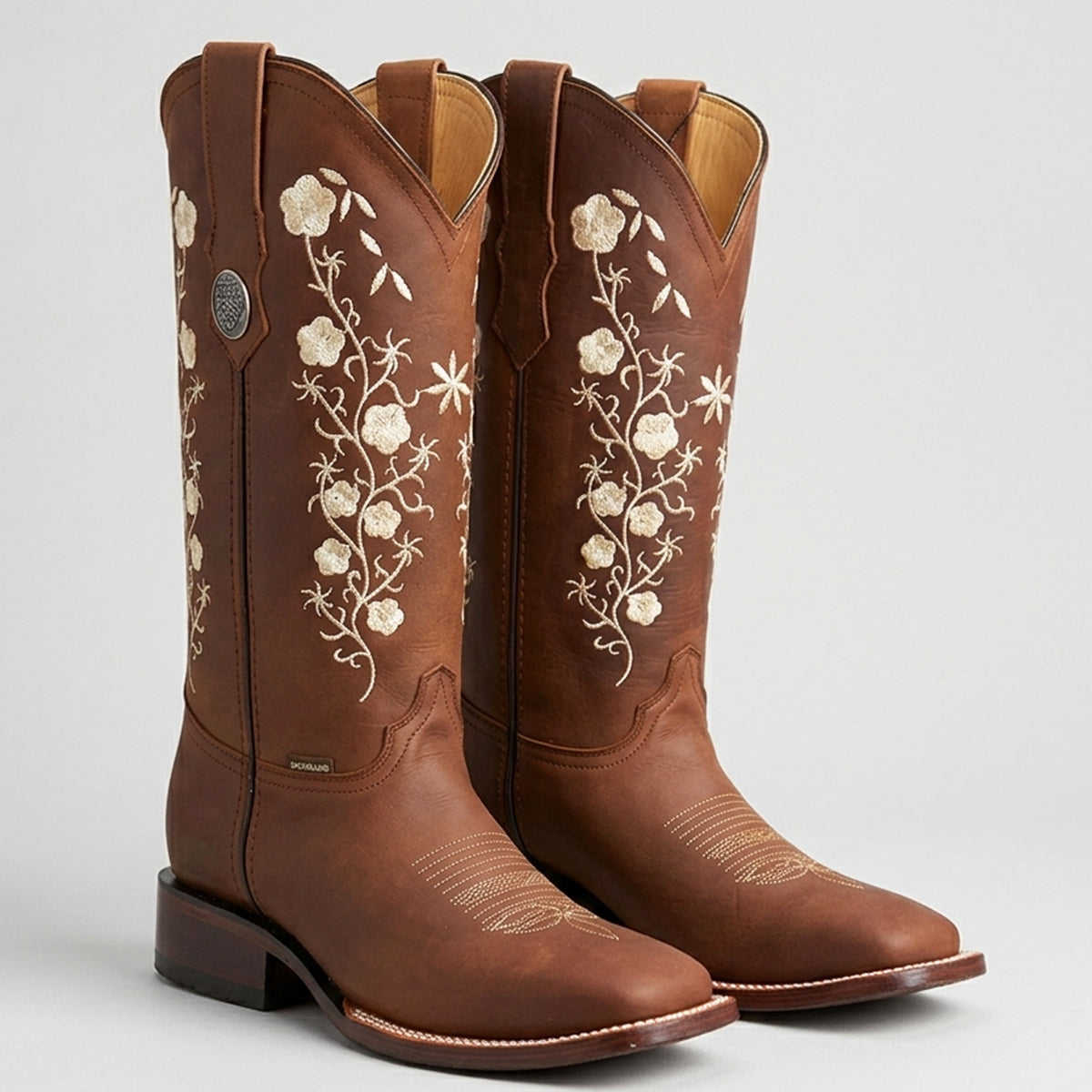 Botas Doble R Dalia Cobre women's copper-brown leather square toe cowgirl boots decorated with floral embroidery along the 11-inch upper shaft.
