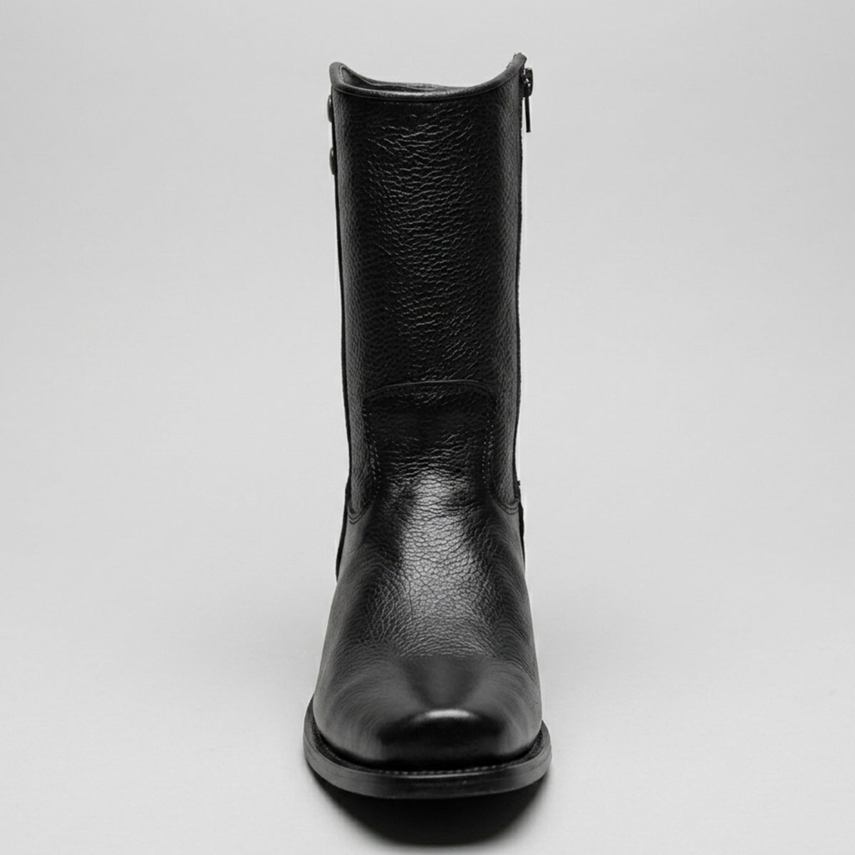 A single black leather mid-calf boot with a pebbled texture, shown from a front-facing perspective against a light gray background.