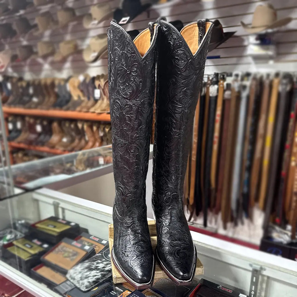 In-store front pair view of the Lirac 17-inch black floral tooled boots highlighting the snip toe profile and double-welt stitched leather sole.