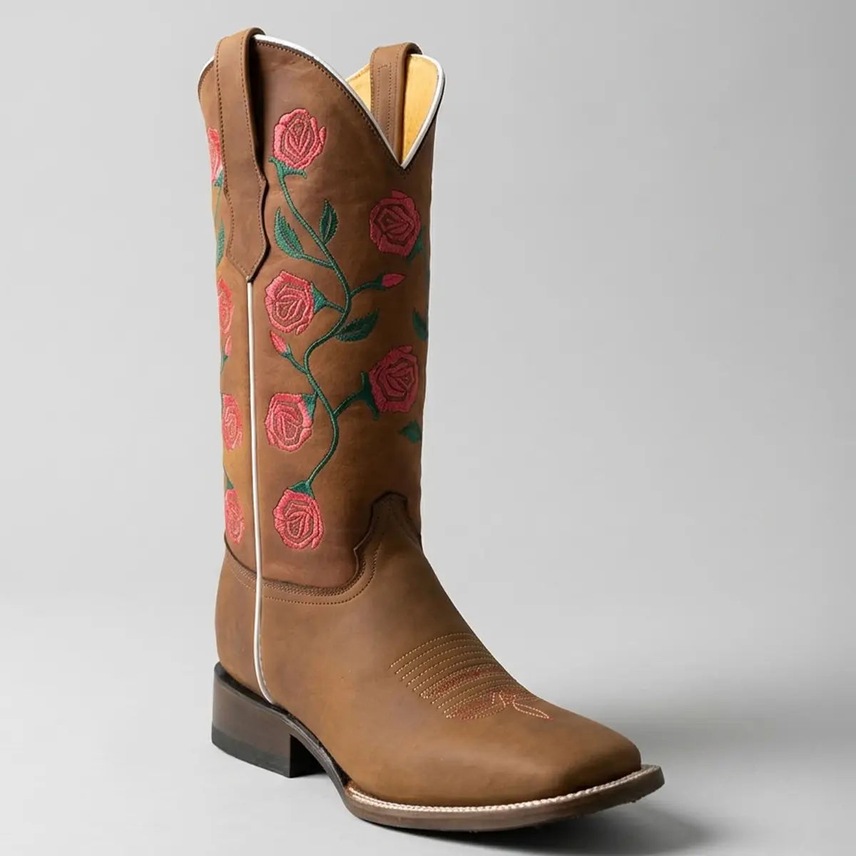Single studio profile view of the Abolengo women's brown leather square toe cowgirl boot showcasing the 11-inch shaft with red rose embroidery, white seam piping, and block heel.