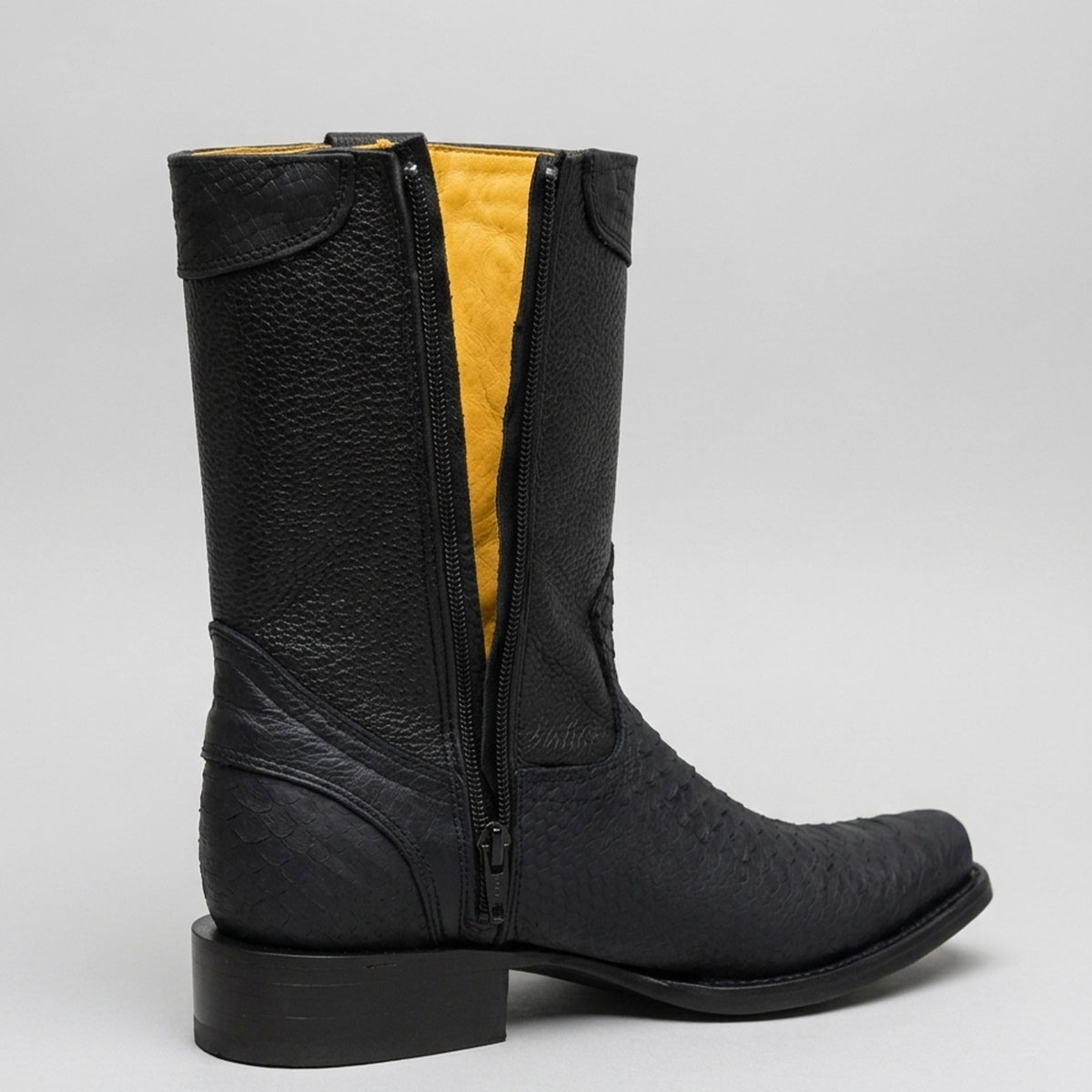 A black leather western boot with a side zipper revealing a bright yellow interior lining, shown from a side profile on a light gray background.