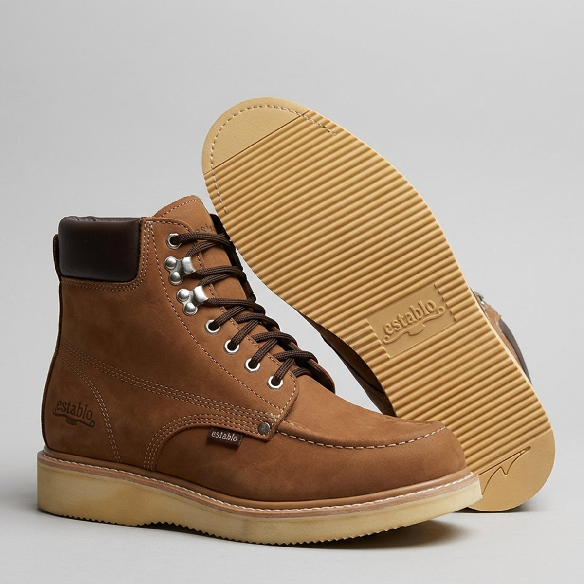 Bottom sole and profile view of the Establo Men's 6-inch moc toe work boot in light tan nubuck leather displaying the cream polyurethane ribbed wedge outsole.