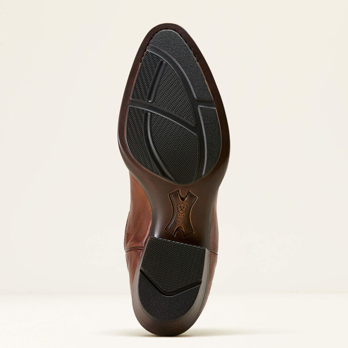 Ariat black rubber sole on a beige background.