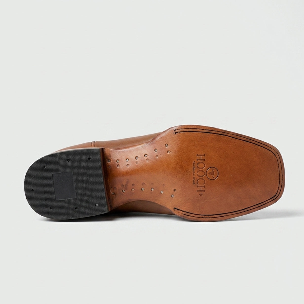 Hooch brown leather sole with black rubber cap on a light gray background.