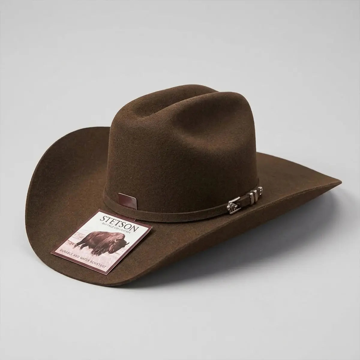 Studio profile view of the Stetson Apache 4X mink cowboy hat with its official Stetson Buffalo Collection tag sitting on the brim.