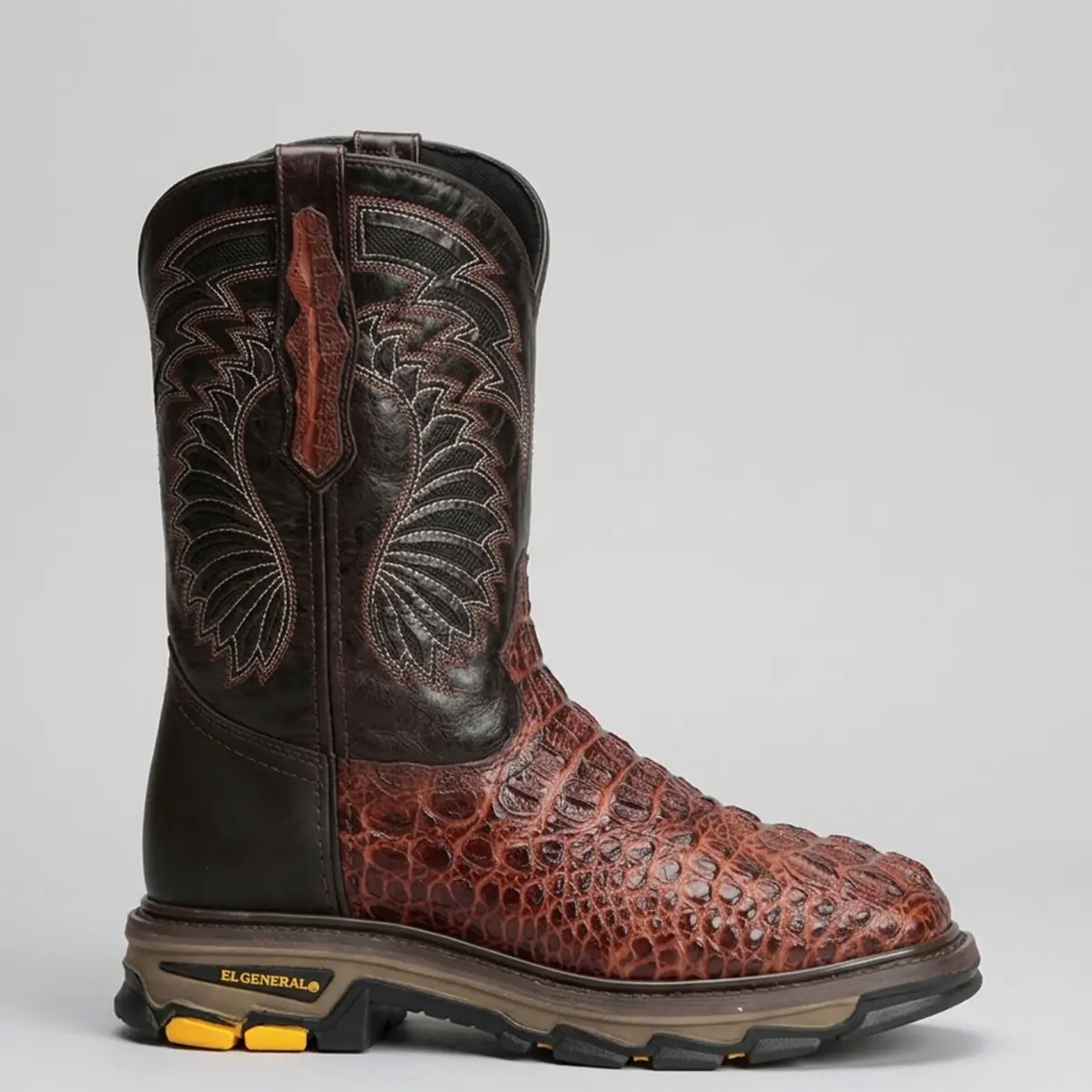 Side studio view of the El General Caiman print Western work boot displaying the textured Caiman foot, multi-row shaft embroidery, pull strap accent, and cushioned El General brand lug sole.