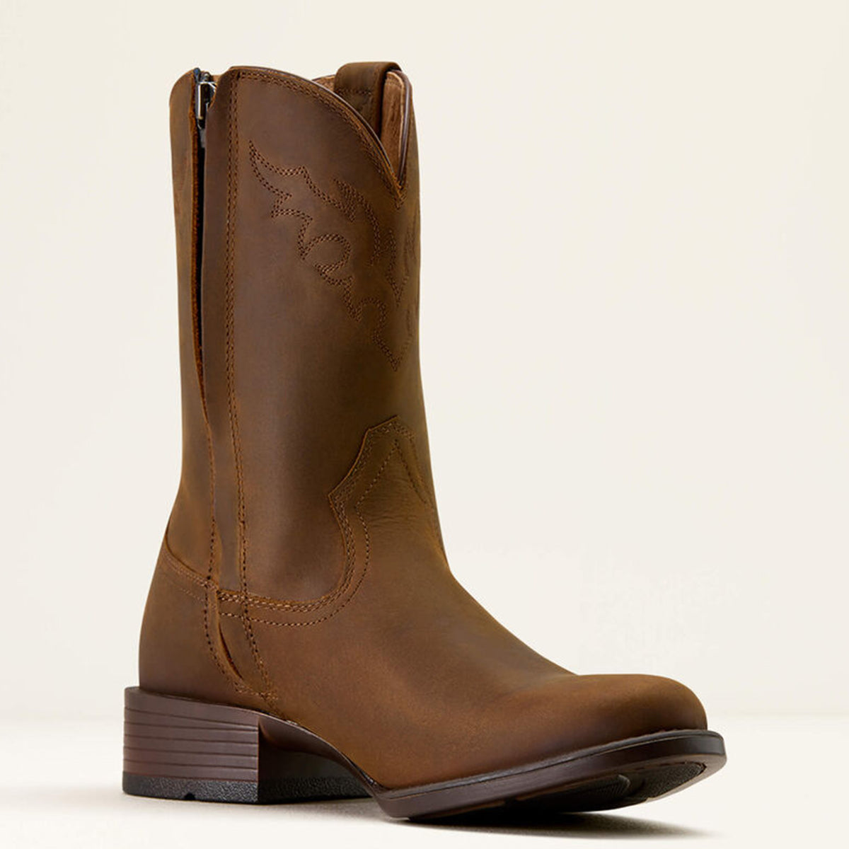 Ariat men's brown leather roper western boot with zipper on a beige background.